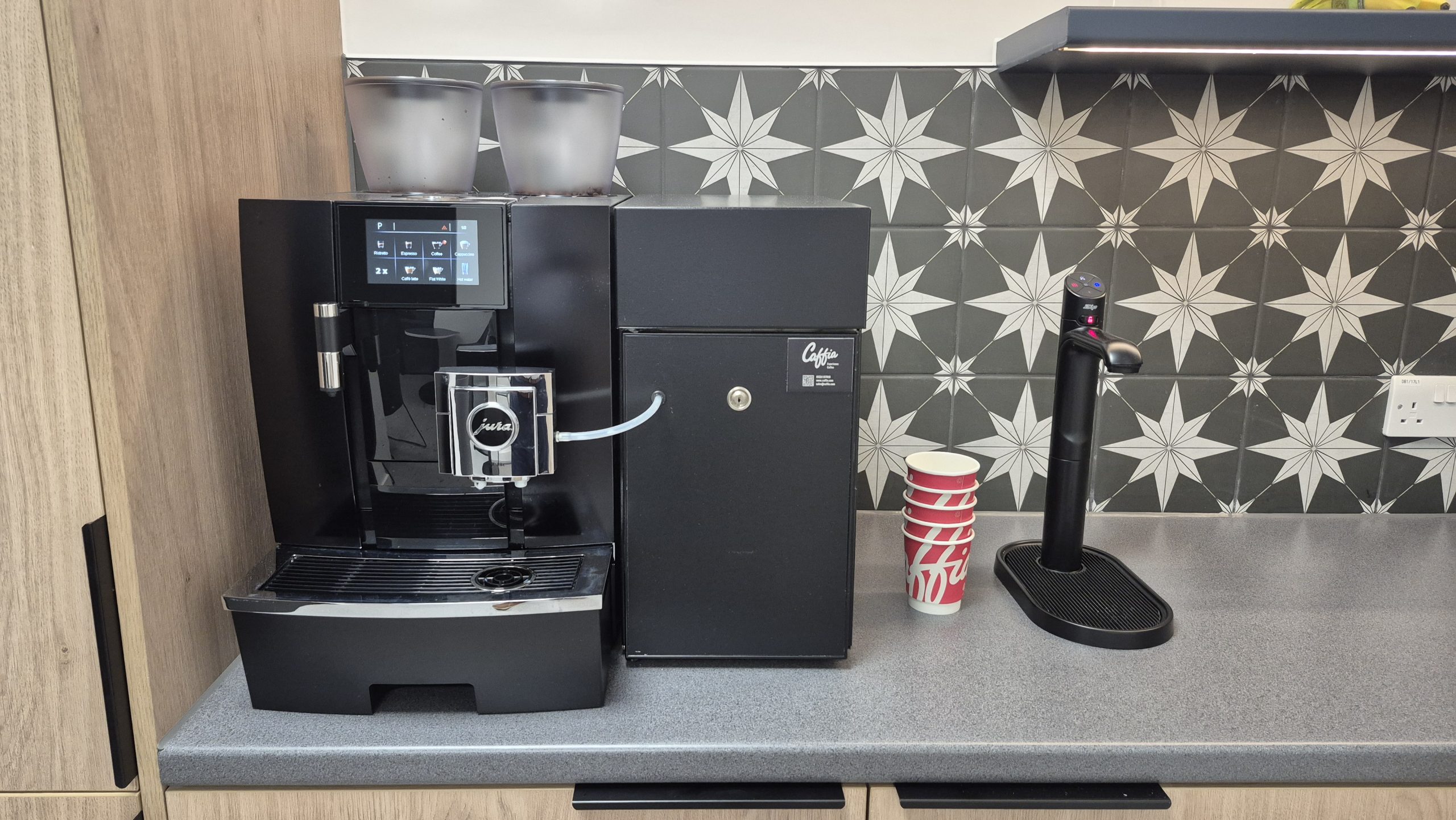 Zip office water tap beside a Jura coffee machine in a workplace drinks area