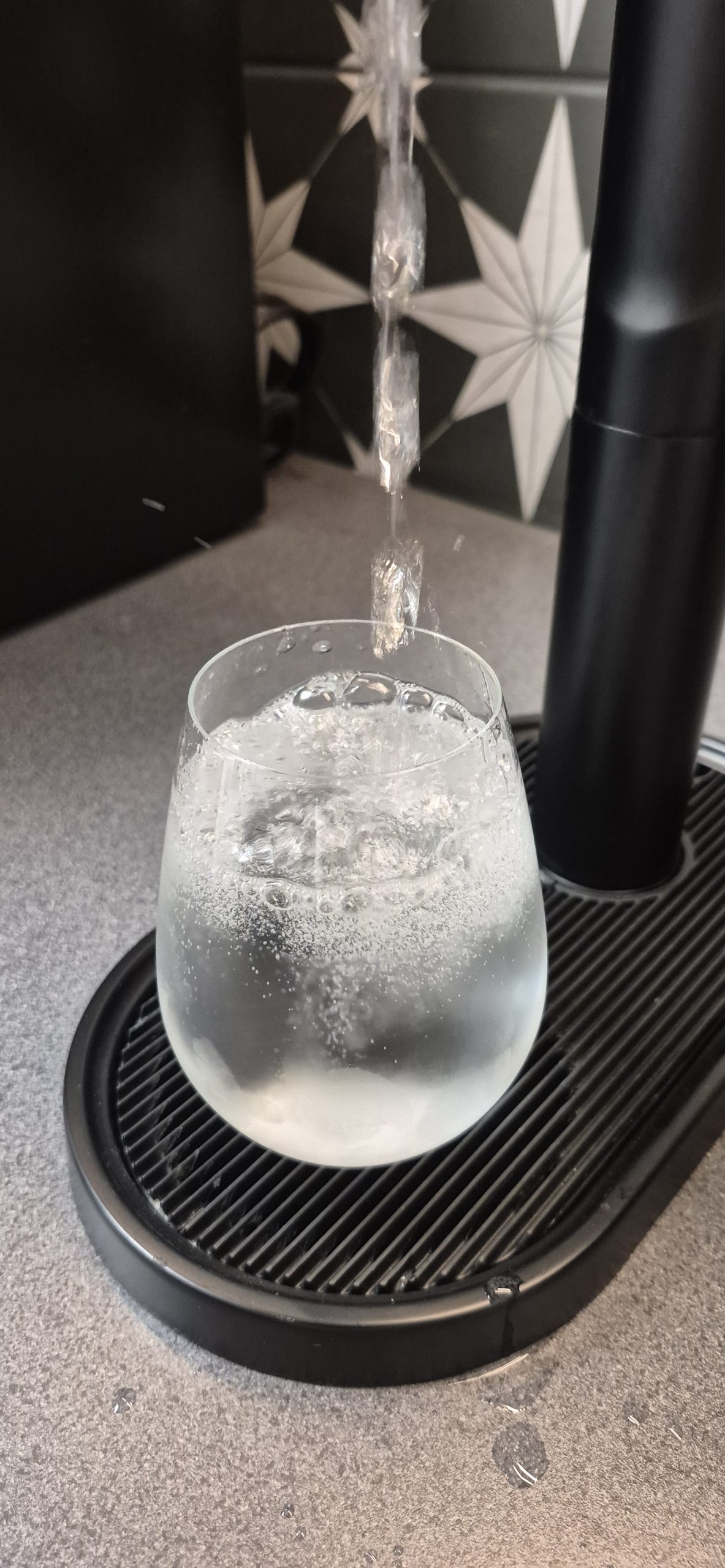 Sparkling filtered water being dispensed from a black Zip HydroTap